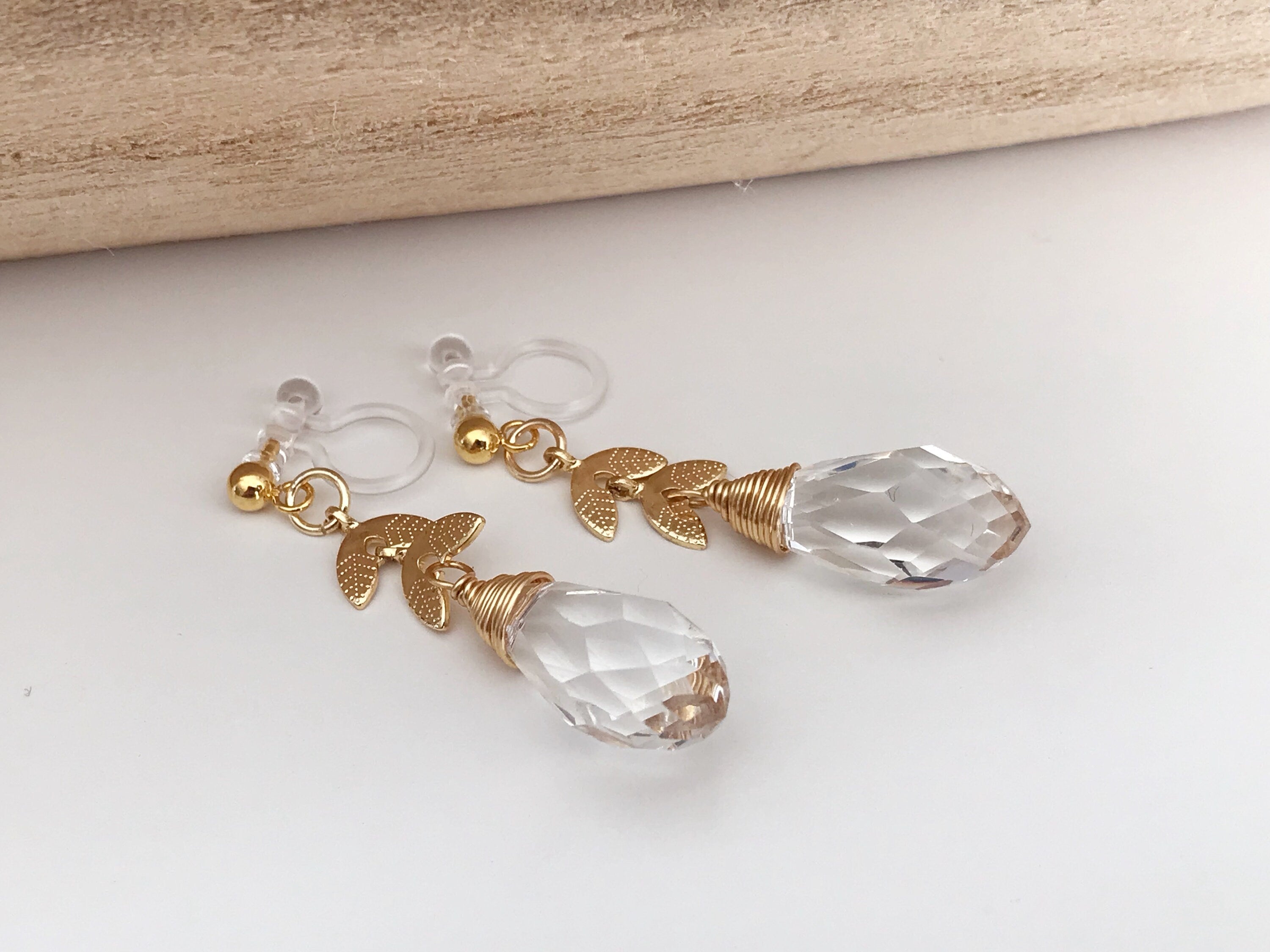 Gold leaf chain dangling ear clips with transparent faceted pearl in the shape of a drop of water Comfortable invisible clips.
