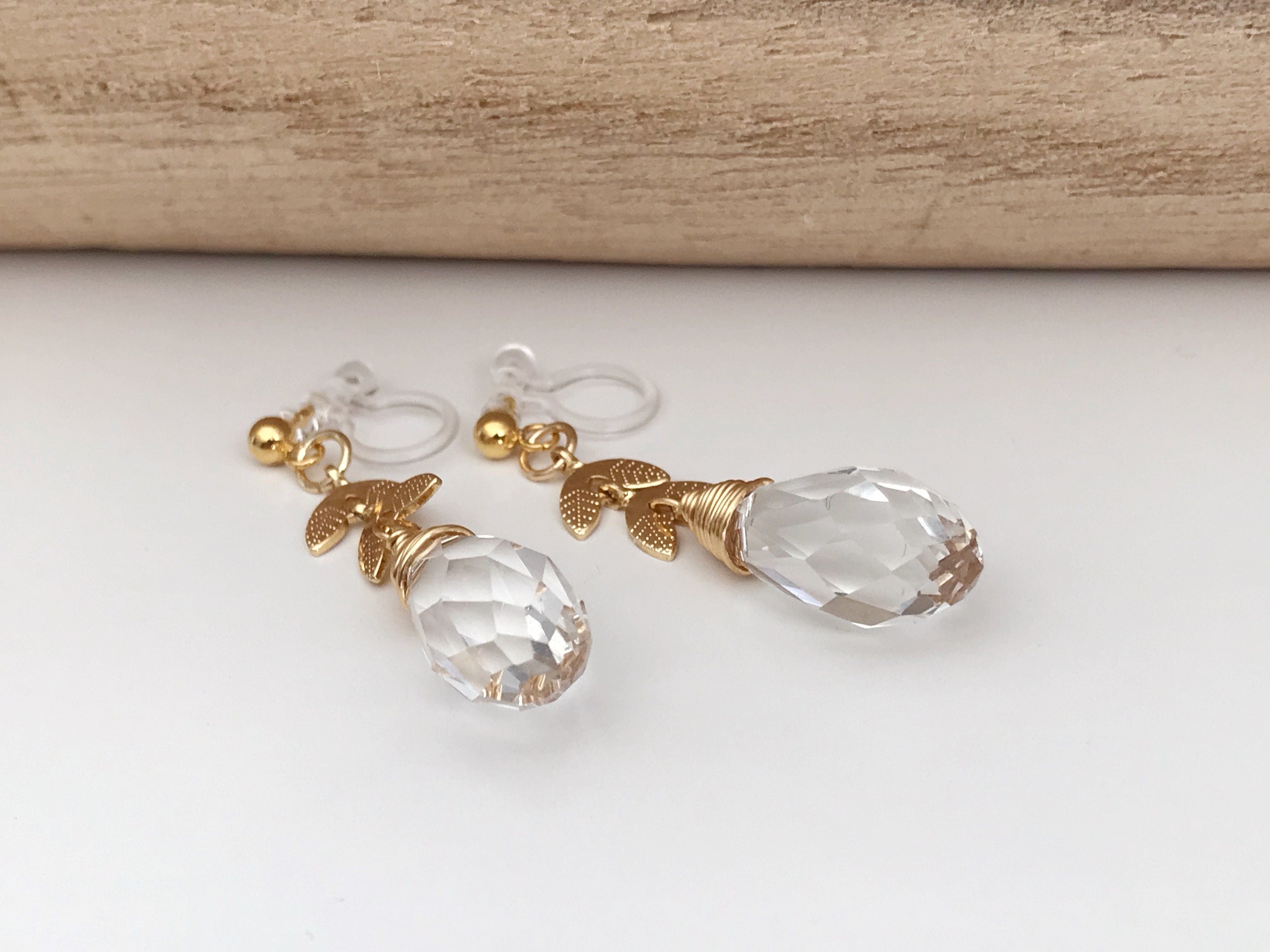 Gold leaf chain dangling ear clips with transparent faceted pearl in the shape of a drop of water Comfortable invisible clips.