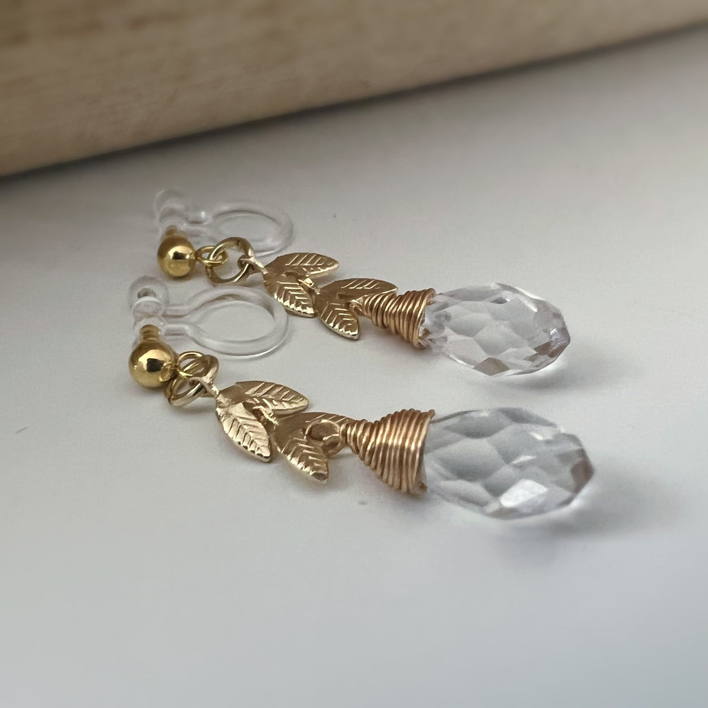 Gold leaf chain dangling ear clips with transparent faceted pearl in the shape of a drop of water Comfortable invisible clips.