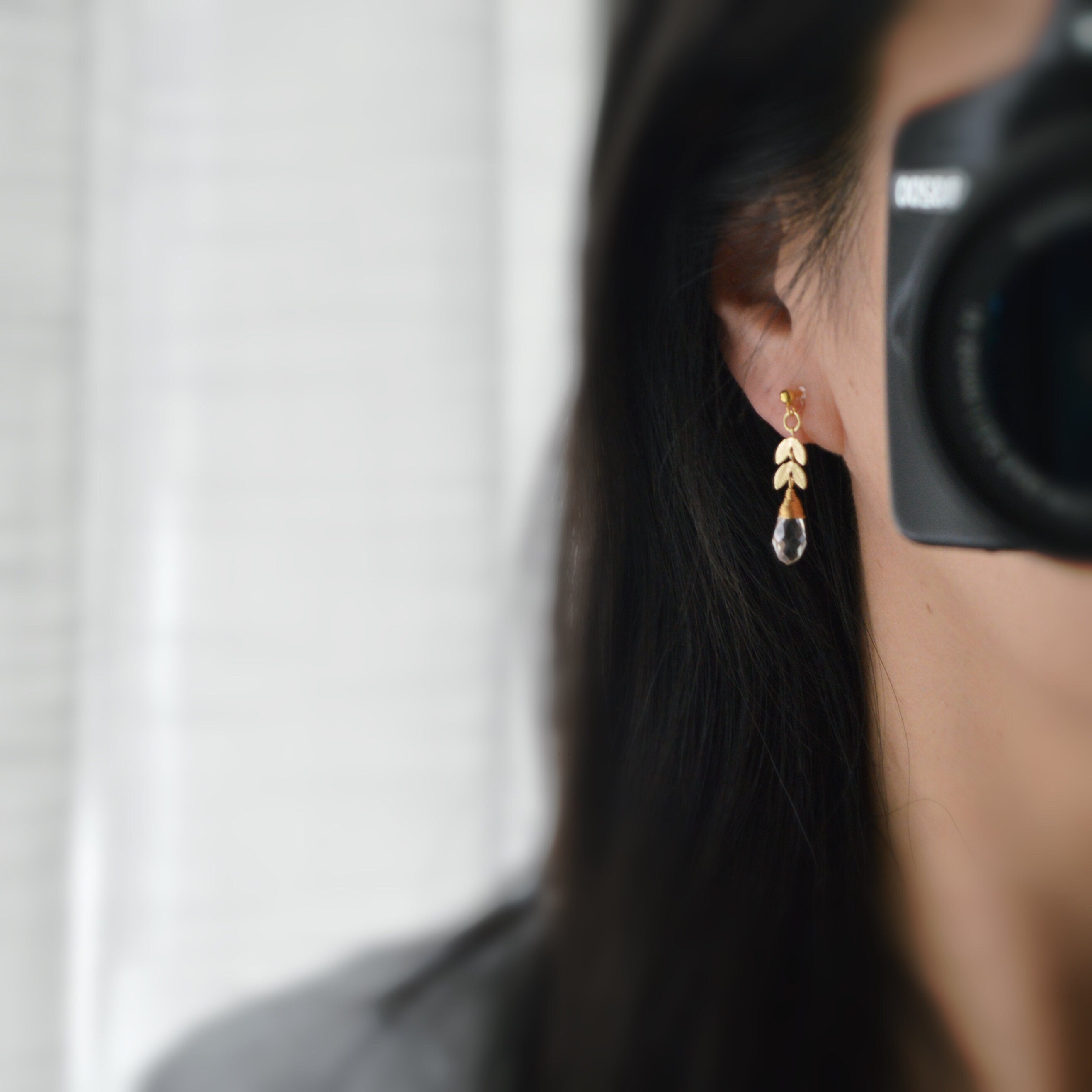 Gold leaf chain dangling ear clips with transparent faceted pearl in the shape of a drop of water Comfortable invisible clips.