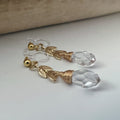 Gold leaf chain dangling ear clips with transparent faceted pearl in the shape of a drop of water Comfortable invisible clips.