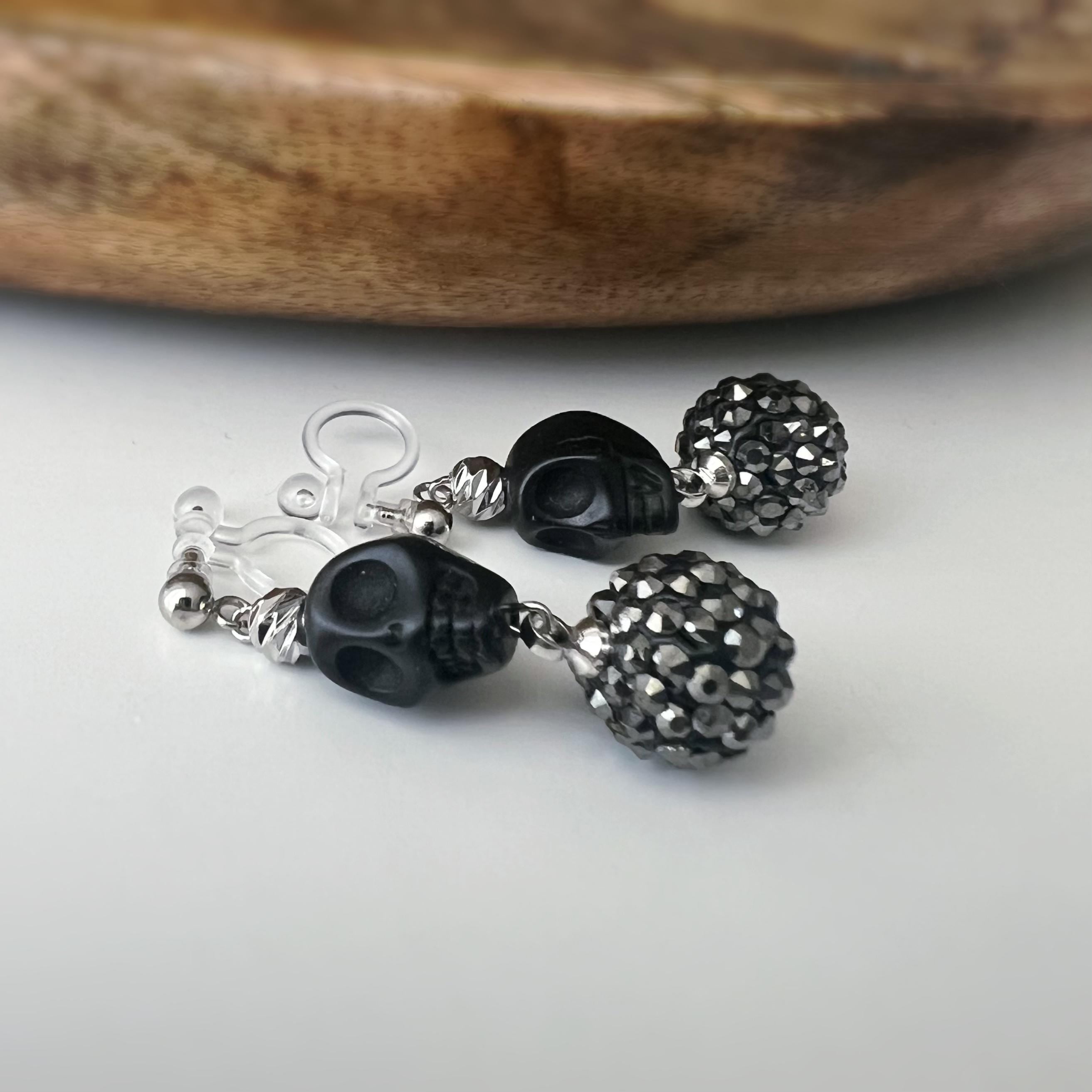 Halloween Boucles d'oreilles Clips pendantes mini Perle sculptée Grande Perle Shambala noire métallisée Tête de mort noir style punk.