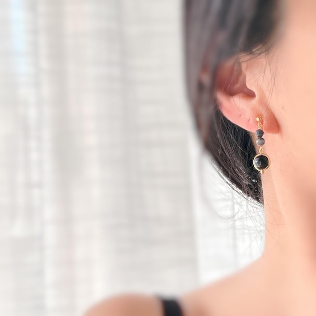 Boucles d'oreilles CLIPS pendantes couleur or, ornées de perles noires et de pierres naturelles grises. Parfaites pour un style raffiné.