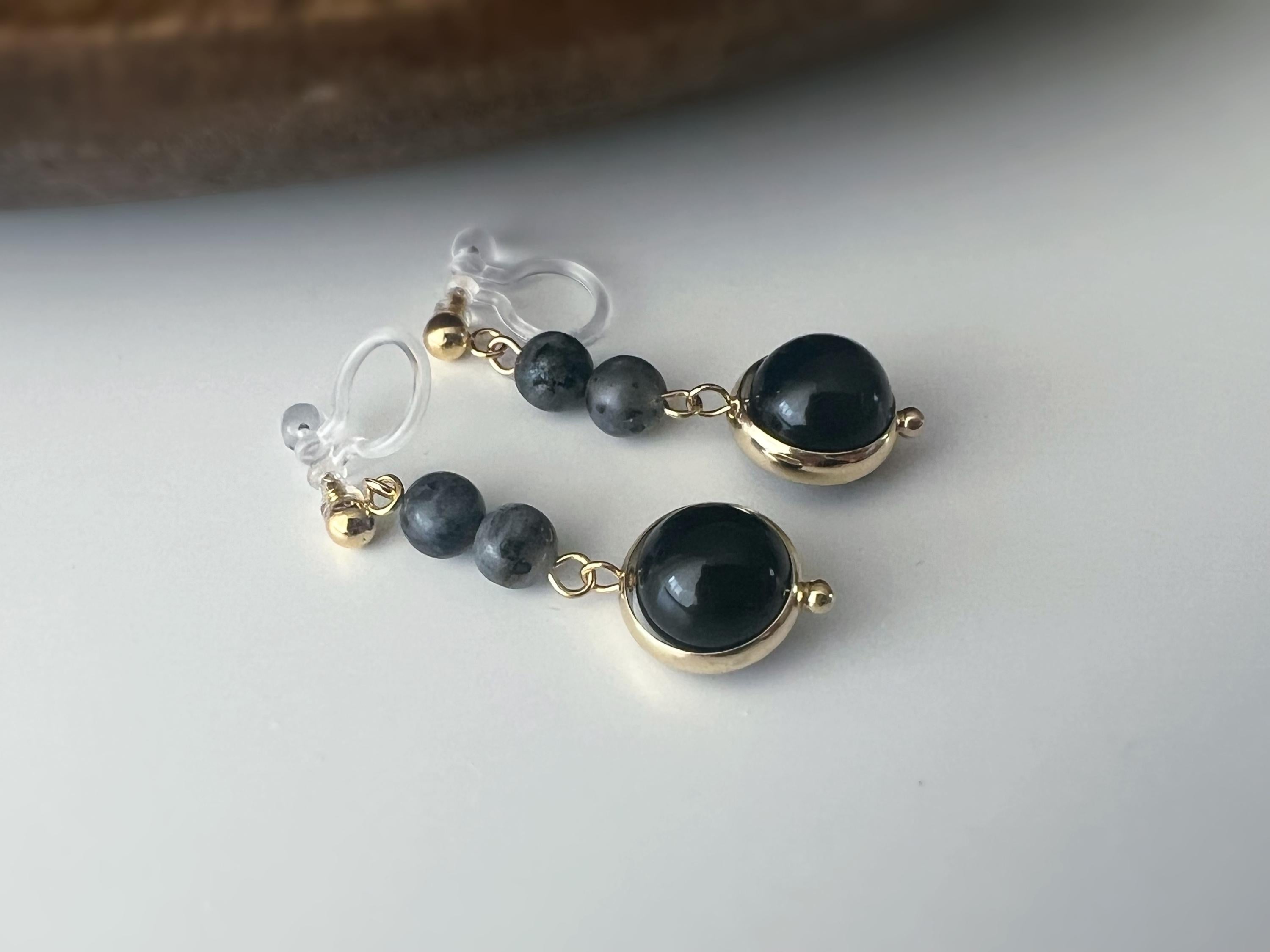 Boucles d'oreilles CLIPS pendantes couleur or, ornées de perles noires et de pierres naturelles grises. Parfaites pour un style raffiné.