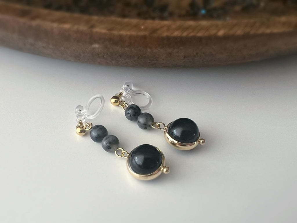 Boucles d'oreilles CLIPS pendantes couleur or, ornées de perles noires et de pierres naturelles grises. Parfaites pour un style raffiné.