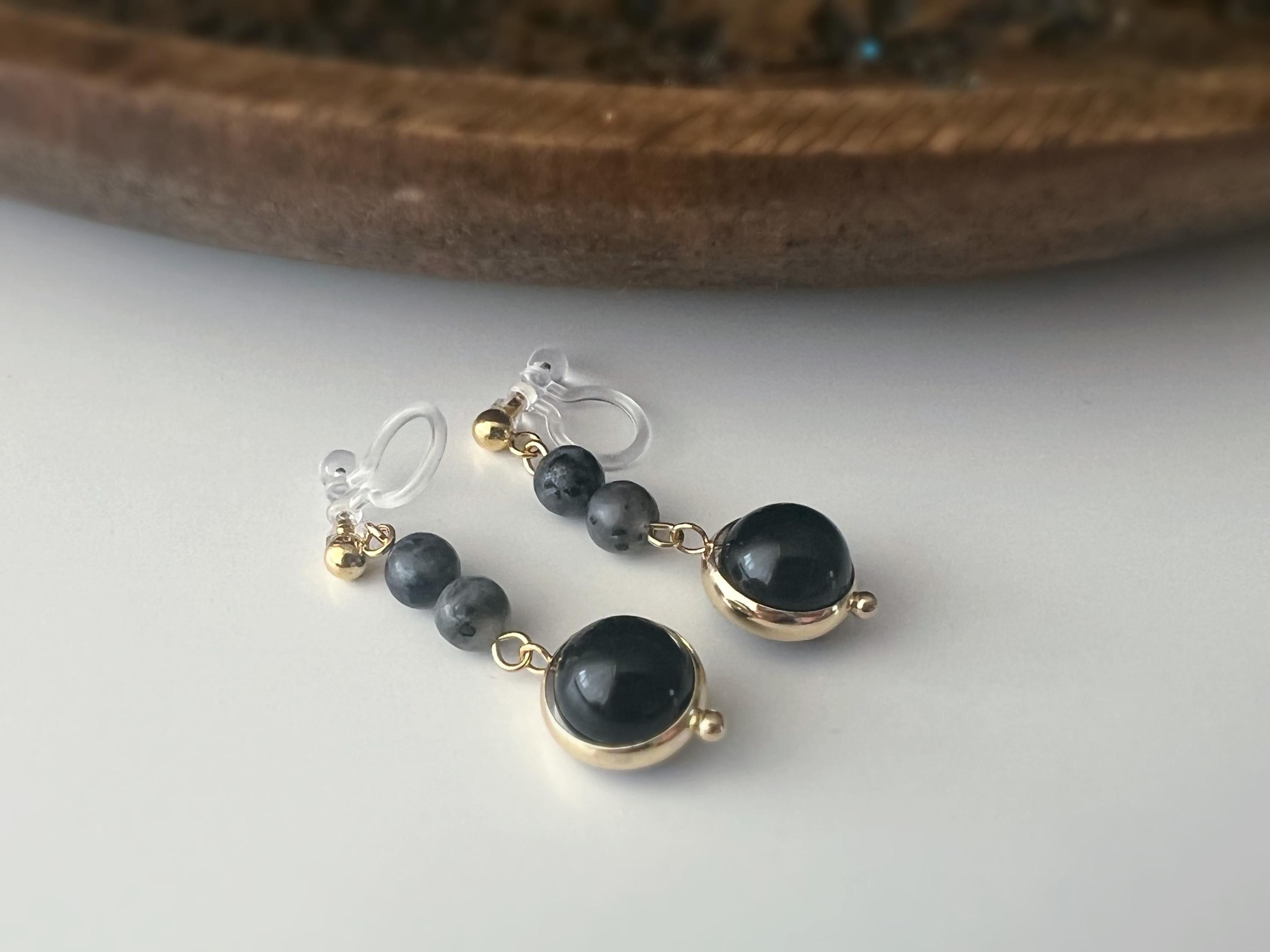 Boucles d'oreilles CLIPS pendantes couleur or, ornées de perles noires et de pierres naturelles grises. Parfaites pour un style raffiné.