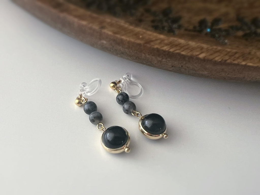Boucles d'oreilles CLIPS pendantes couleur or, ornées de perles noires et de pierres naturelles grises. Parfaites pour un style raffiné.