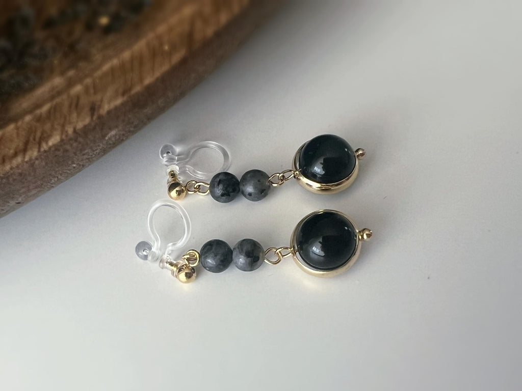 Boucles d'oreilles CLIPS pendantes couleur or, ornées de perles noires et de pierres naturelles grises. Parfaites pour un style raffiné.