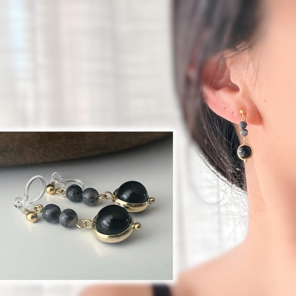 Boucles d'oreilles CLIPS pendantes couleur or, ornées de perles noires et de pierres naturelles grises. Parfaites pour un style raffiné.
