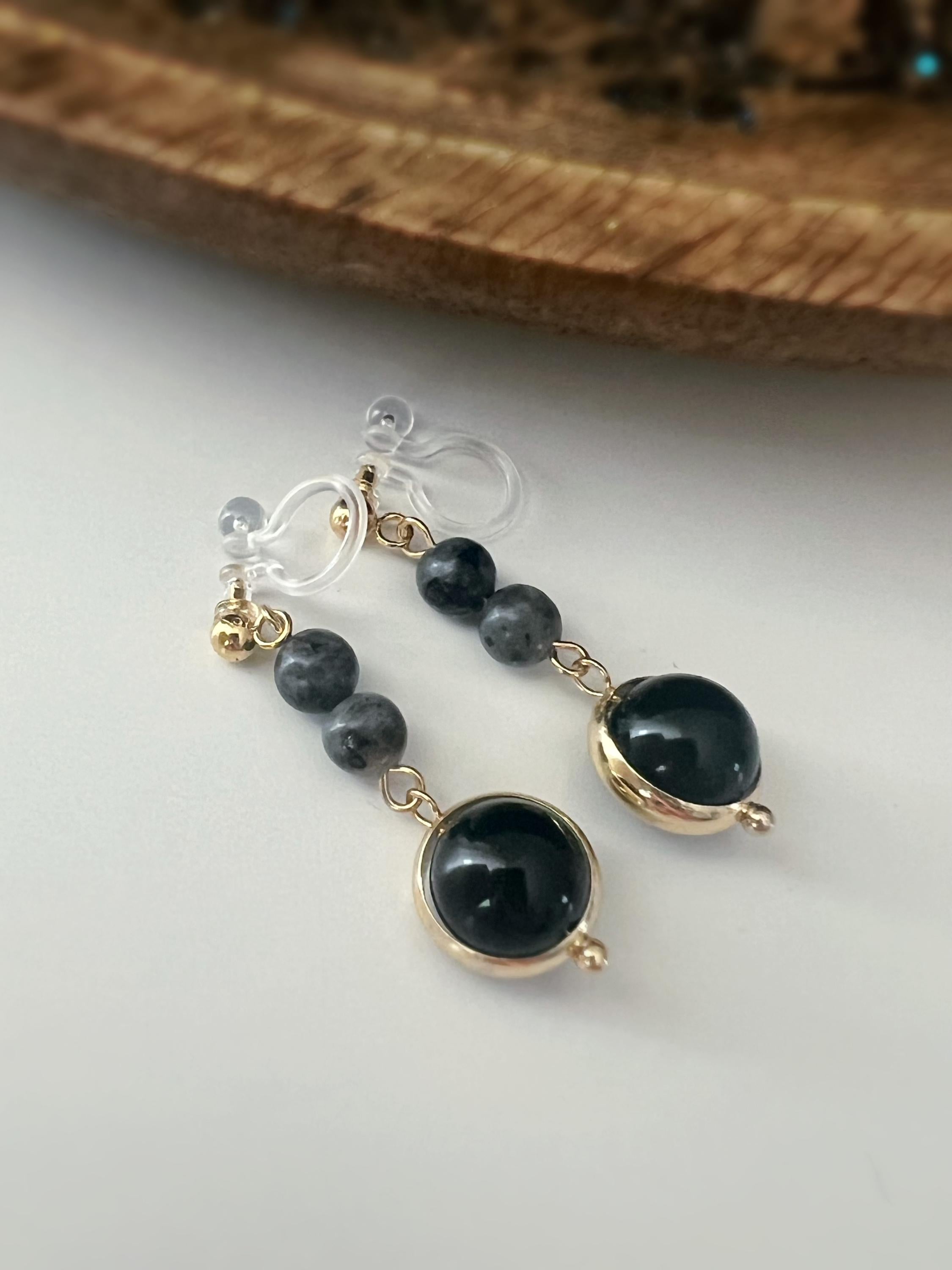 Boucles d'oreilles CLIPS pendantes couleur or, ornées de perles noires et de pierres naturelles grises. Parfaites pour un style raffiné.