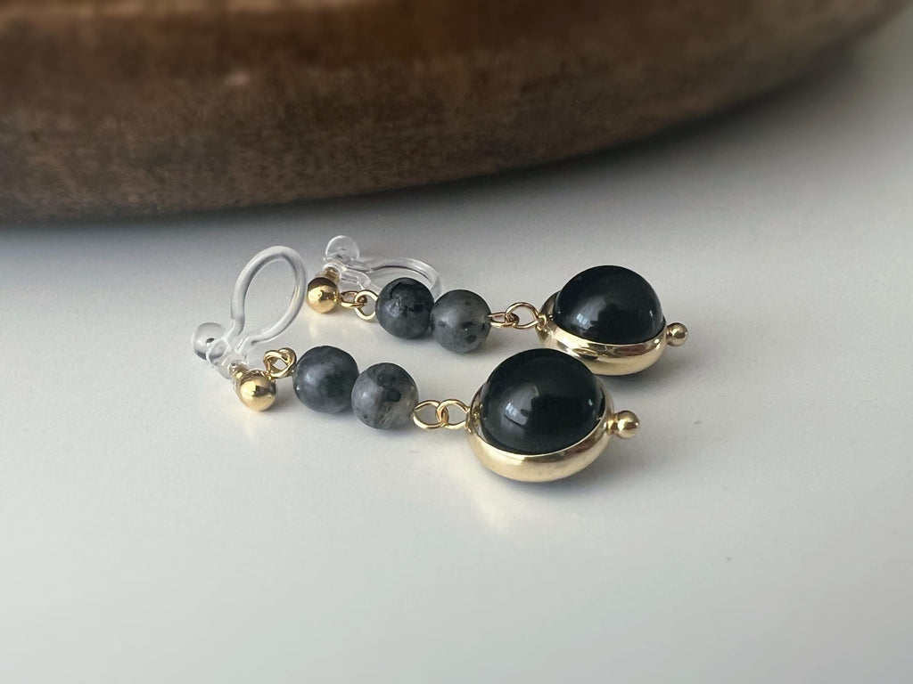 Boucles d'oreilles CLIPS pendantes couleur or, ornées de perles noires et de pierres naturelles grises. Parfaites pour un style raffiné.