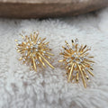 Clips d'oreilles dorés en forme de rayons lumineux, sertis de cristaux étincelants. Une touche glamour idéale pour sublimer vos tenues.