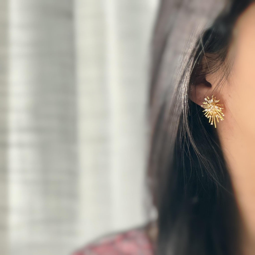 Clips d'oreilles dorés en forme de rayons lumineux, sertis de cristaux étincelants. Une touche glamour idéale pour sublimer vos tenues.