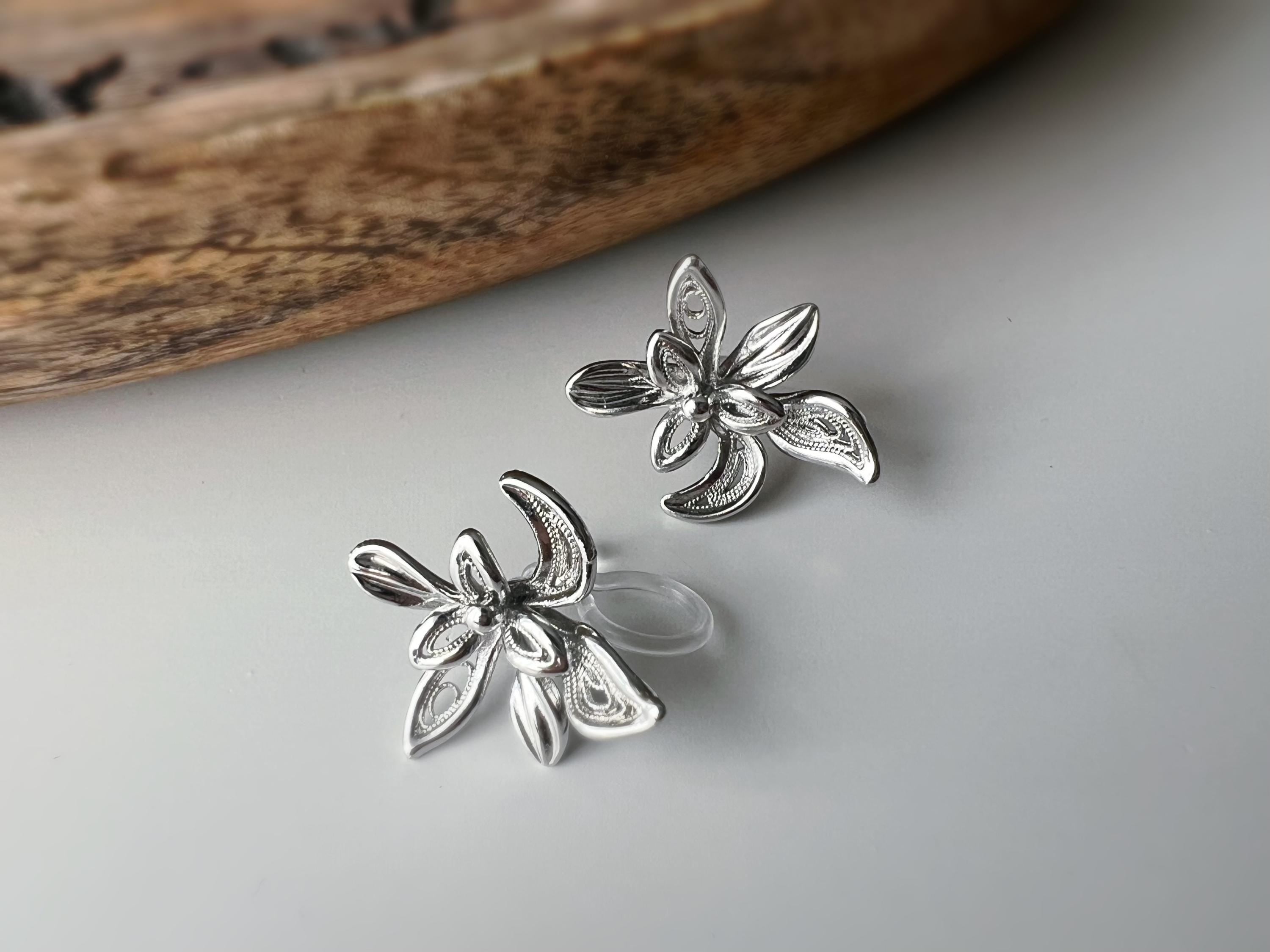 Boucles d'oreilles clip fleur argentée, au design ajouré raffiné. Légères et confortables, parfaites pour sublimer vos looks sans perçage.