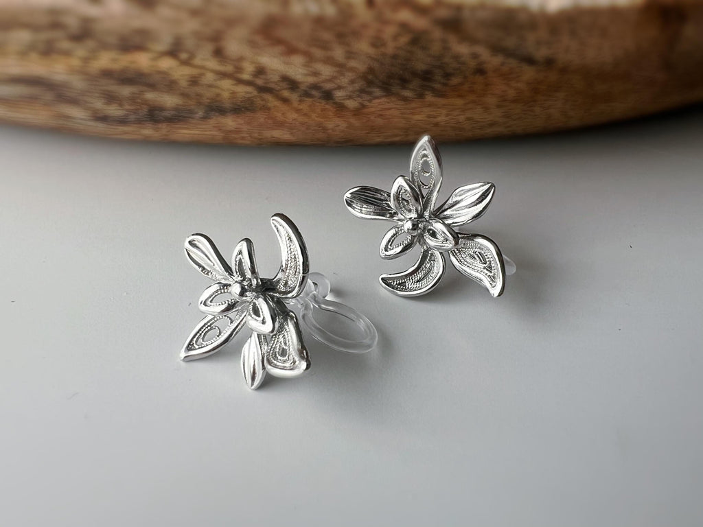 Boucles d'oreilles clip fleur argentée, au design ajouré raffiné. Légères et confortables, parfaites pour sublimer vos looks sans perçage.
