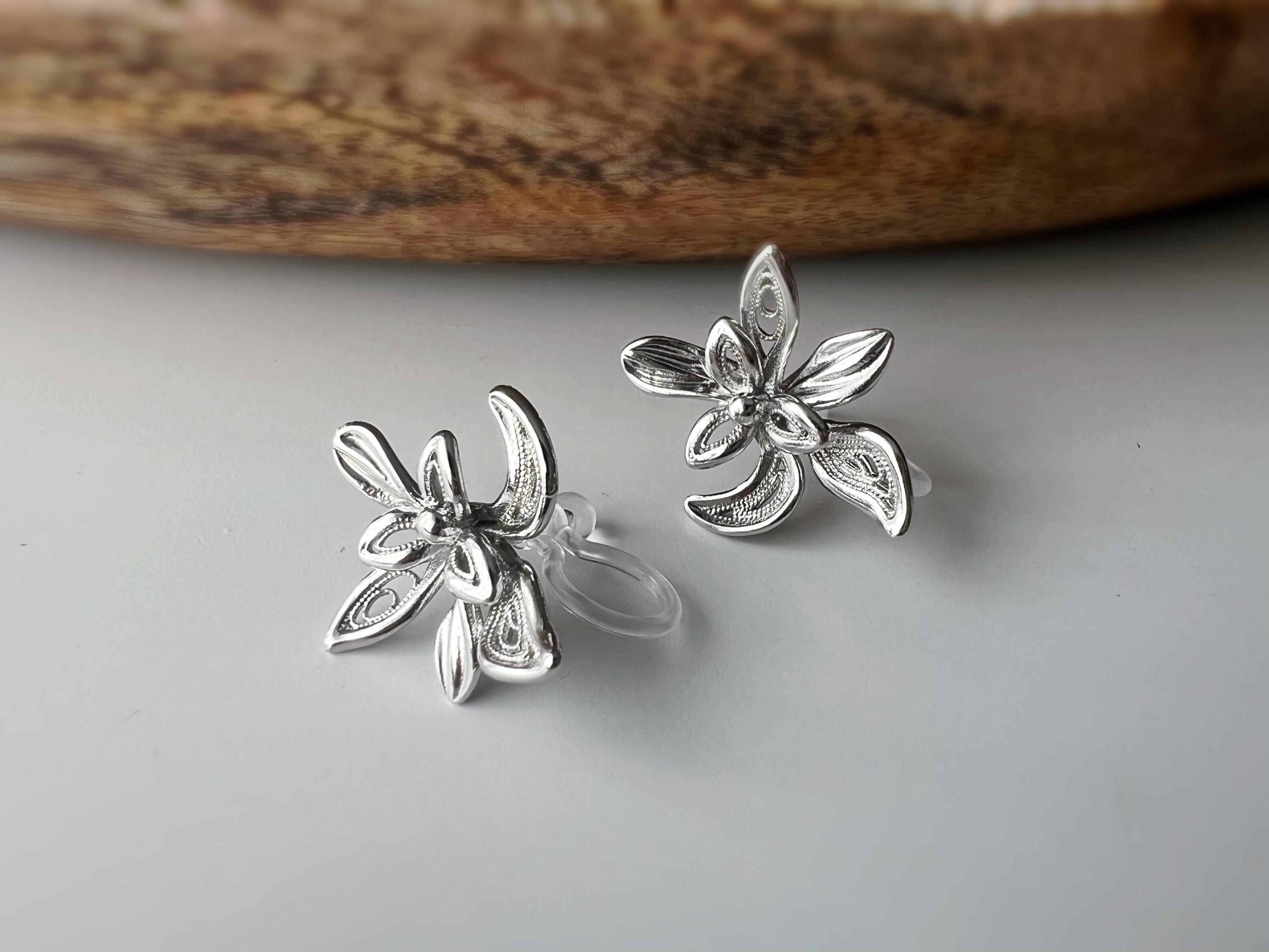 Boucles d'oreilles clip fleur argentée, au design ajouré raffiné. Légères et confortables, parfaites pour sublimer vos looks sans perçage.