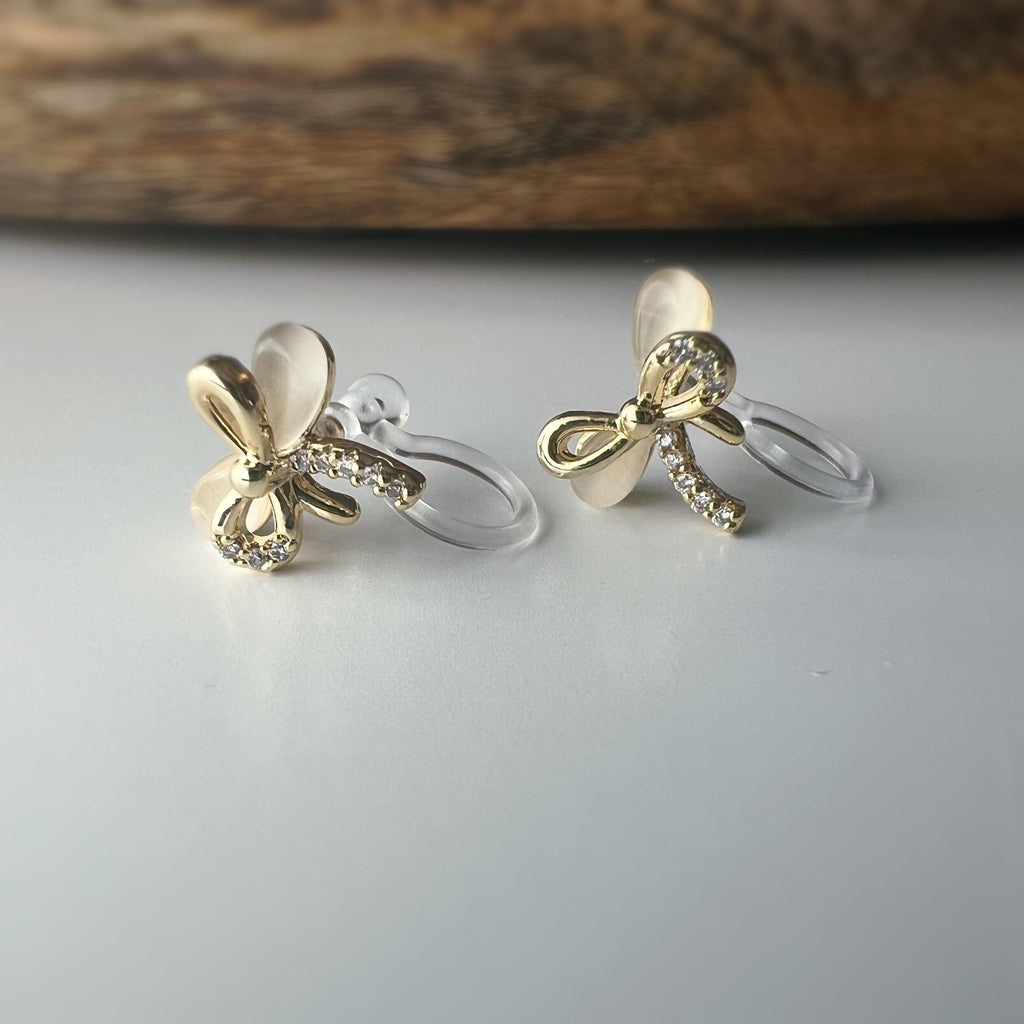 Boucles d'oreilles clip en forme de nœud doré ornées strass scintillants Délicates elles ajoutent une touche de charme raffiné à votre style