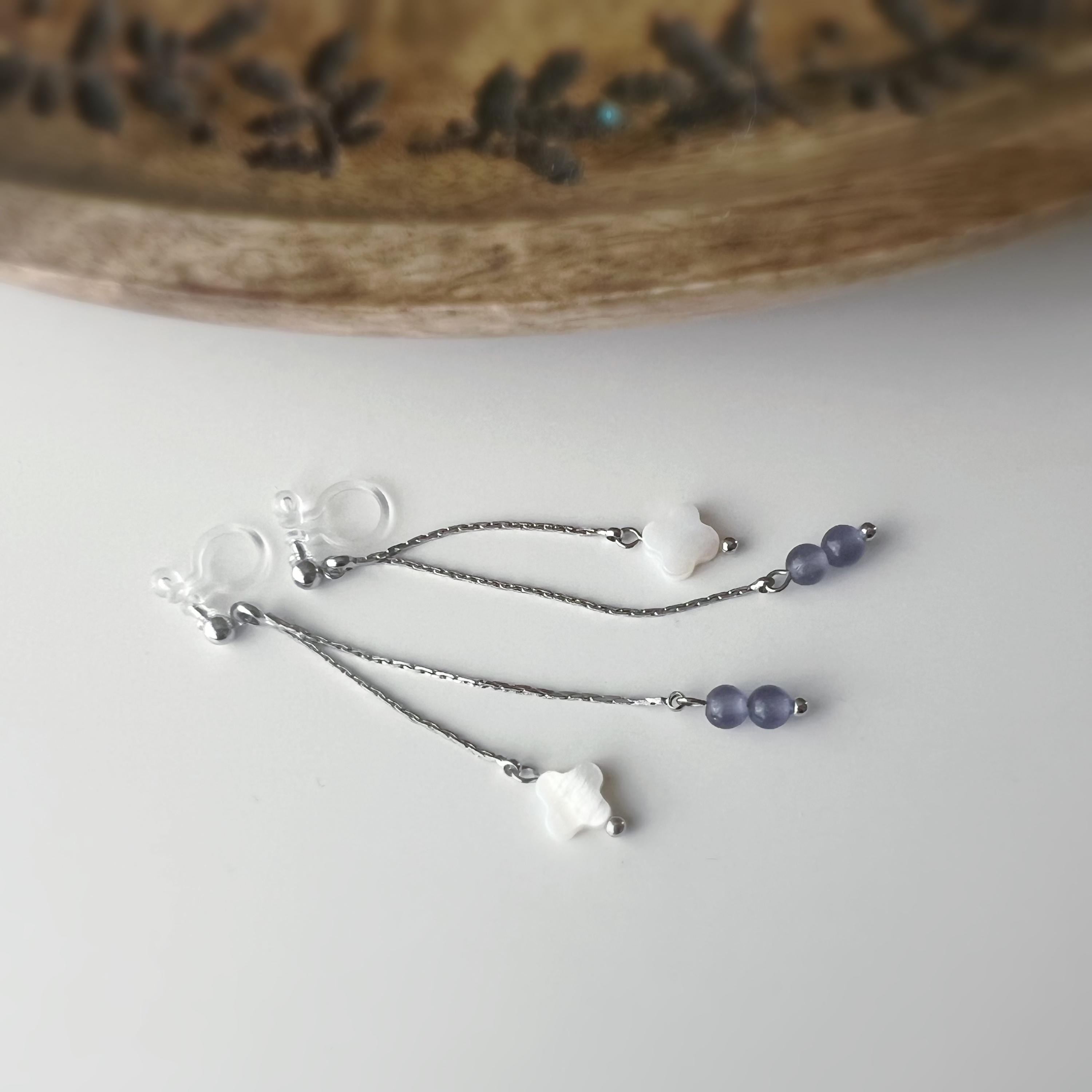 Boucles d'oreilles clip élégantes Chaîne argentée Perles violettes Fleur blanche en nacre Légères raffinées parfait pour style délicat chic.