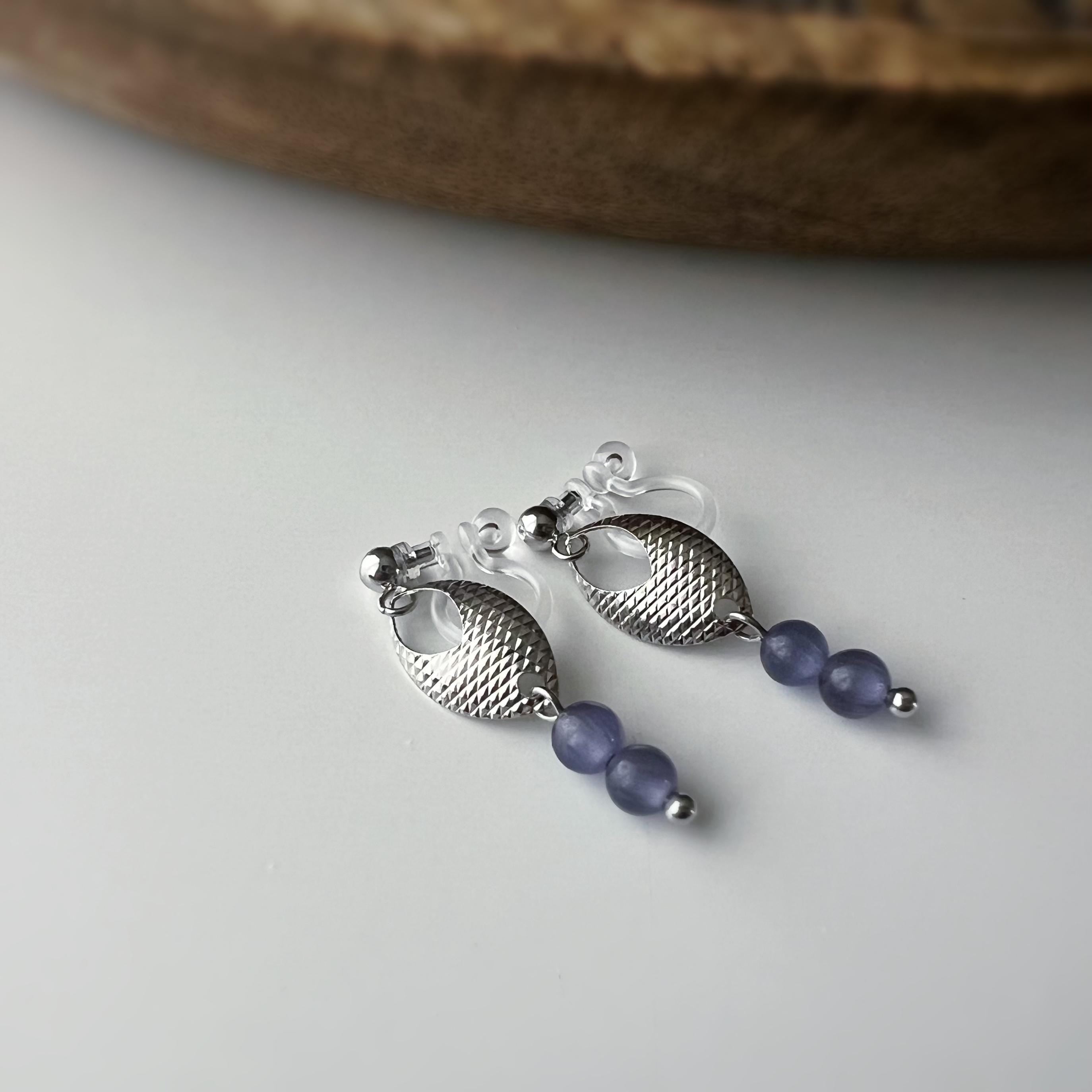 Boucles d'oreilles clip élégantes en argent avec perles violettes. Design raffiné et sans perçage, parfait pour un look chic et sophistiqué.