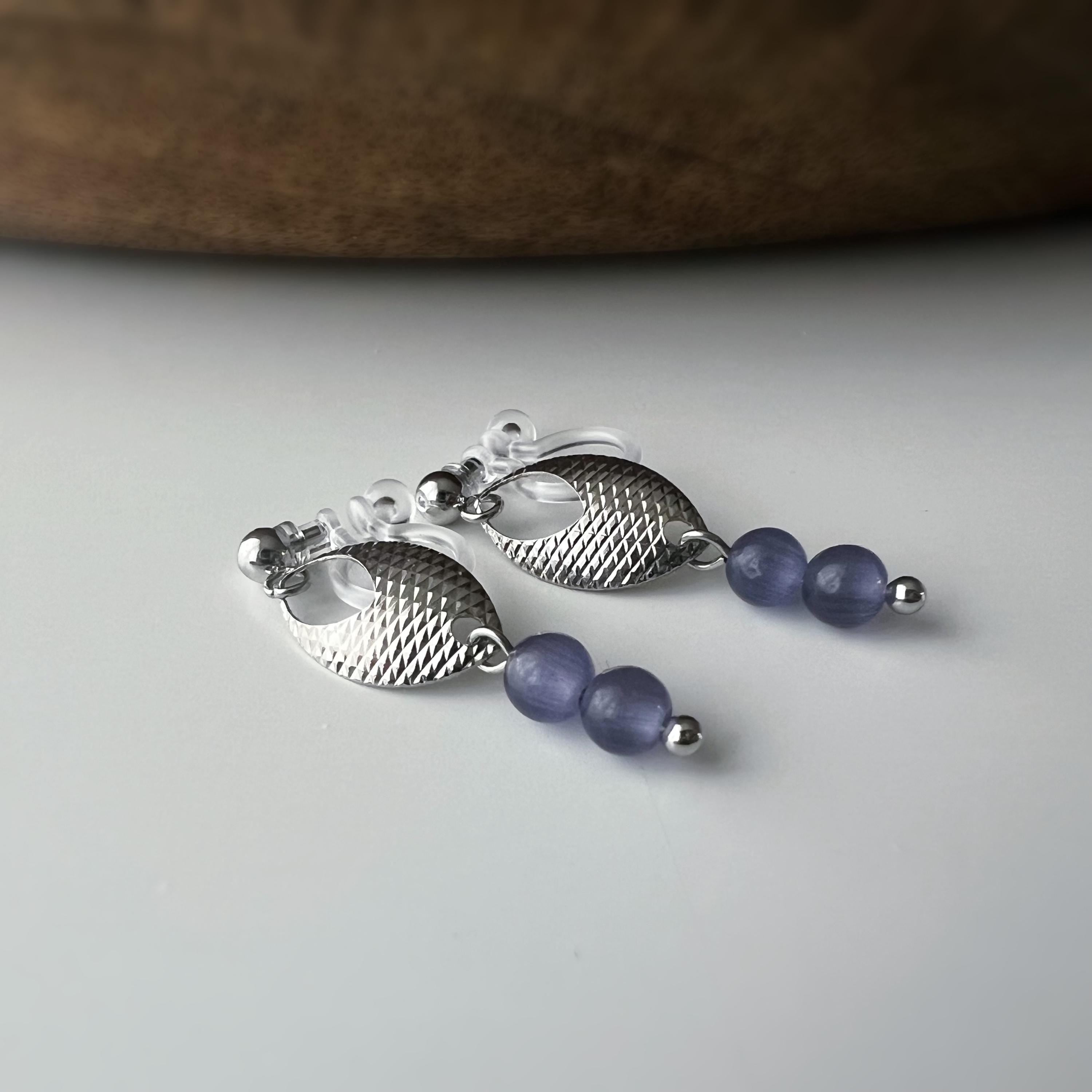 Boucles d'oreilles clip élégantes en argent avec perles violettes. Design raffiné et sans perçage, parfait pour un look chic et sophistiqué.