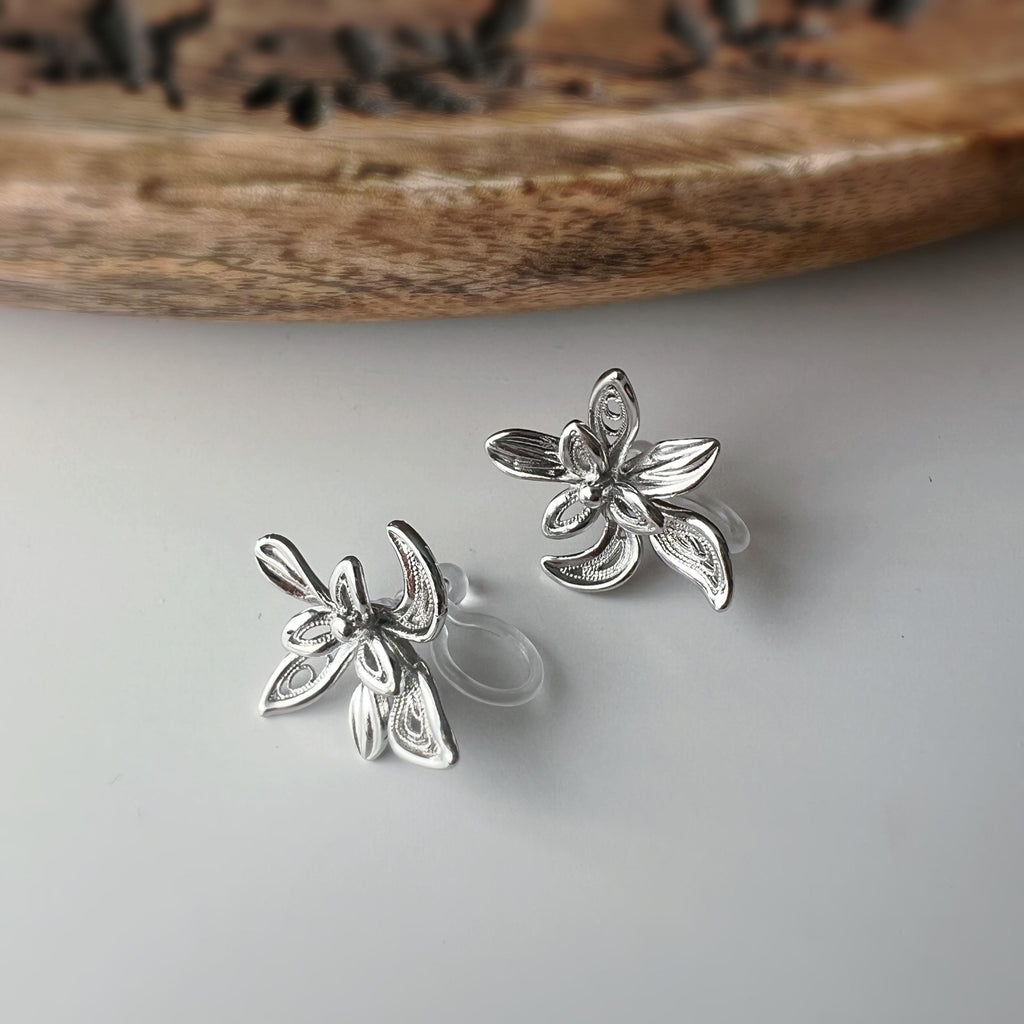 Boucles d'oreilles clip fleur argentée, au design ajouré raffiné. Légères et confortables, parfaites pour sublimer vos looks sans perçage.