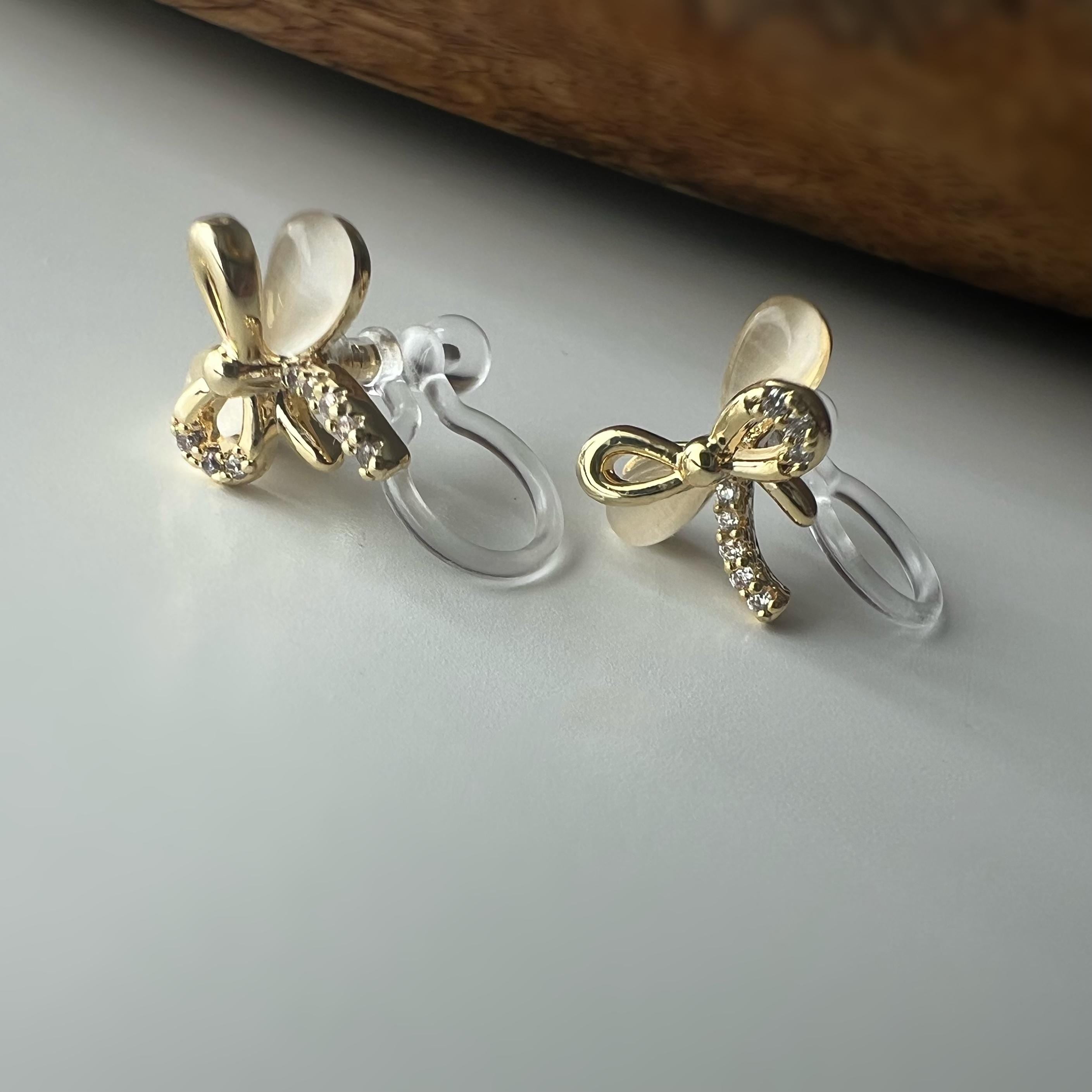 Boucles d'oreilles clip en forme de nœud doré ornées strass scintillants Délicates elles ajoutent une touche de charme raffiné à votre style
