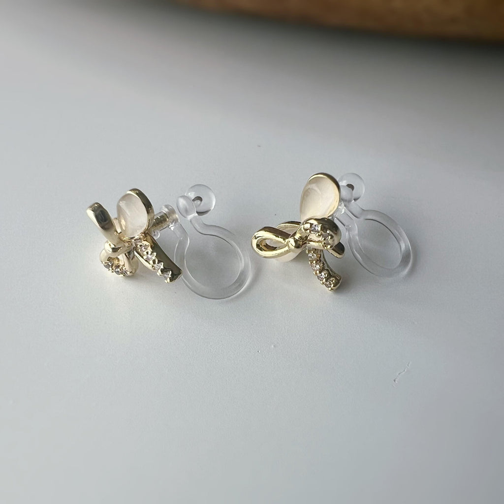 Boucles d'oreilles clip en forme de nœud doré ornées strass scintillants Délicates elles ajoutent une touche de charme raffiné à votre style