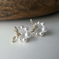 Boucles d’oreilles clip forme de couronne ornées perles blanches, strass scintillants. Finition dorée raffinée pour une touche sophistiquée.