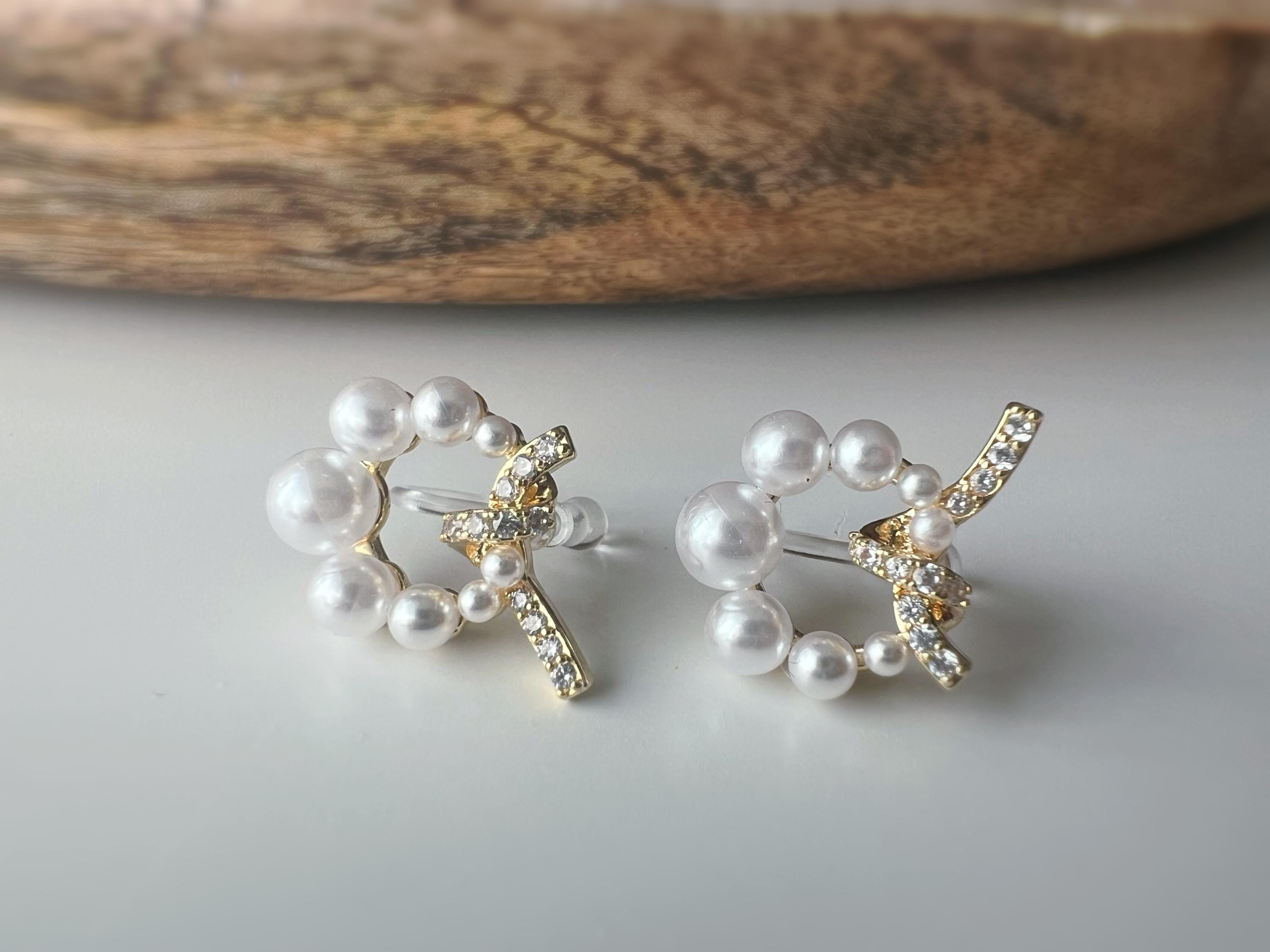 Boucles d’oreilles clip forme de couronne ornées perles blanches, strass scintillants. Finition dorée raffinée pour une touche sophistiquée.