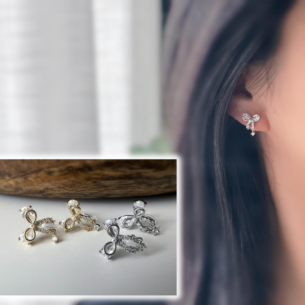 Clips d’oreilles papillon en strass, disponibles en doré et argenté. Design raffiné pour un look délicat, sans perçage.