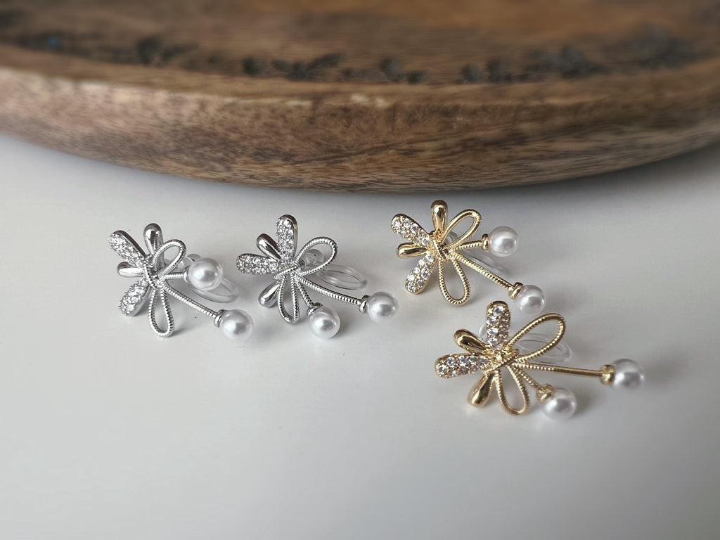 Boucles d’oreilles à clips fleurs strass, mini perles blanches couleur Or / Argent. Design raffiné pour un look délicat, sans perçage.