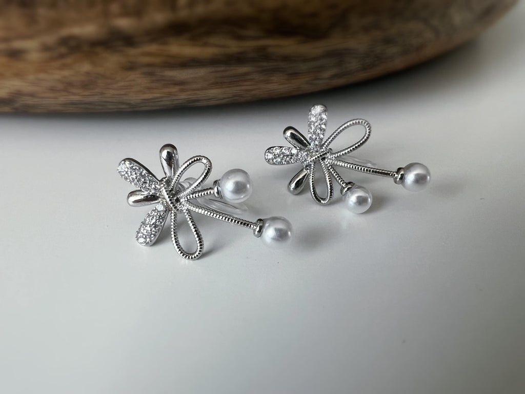 Boucles d’oreilles à clips fleurs strass, mini perles blanches couleur Or / Argent. Design raffiné pour un look délicat, sans perçage.