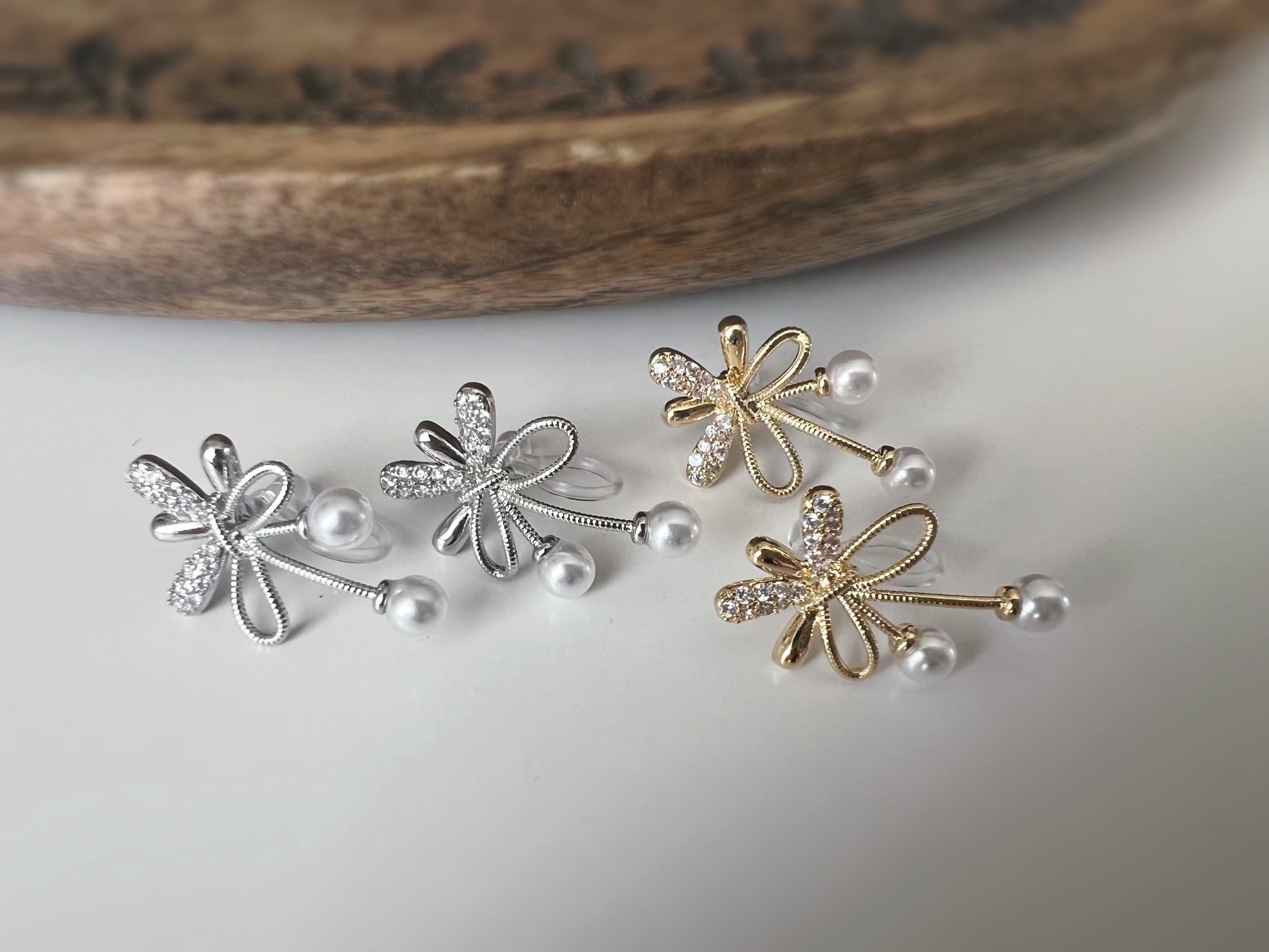 Boucles d’oreilles à clips fleurs strass, mini perles blanches couleur Or / Argent. Design raffiné pour un look délicat, sans perçage.