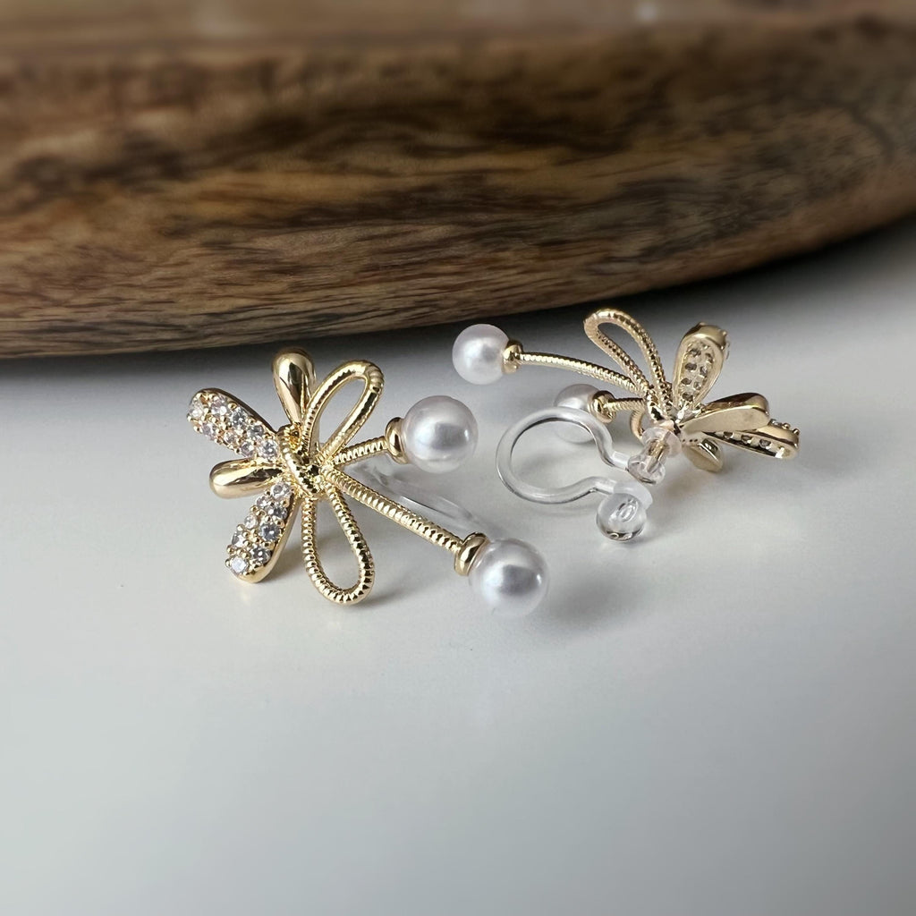 Boucles d’oreilles à clips fleurs strass, mini perles blanches couleur Or / Argent. Design raffiné pour un look délicat, sans perçage.