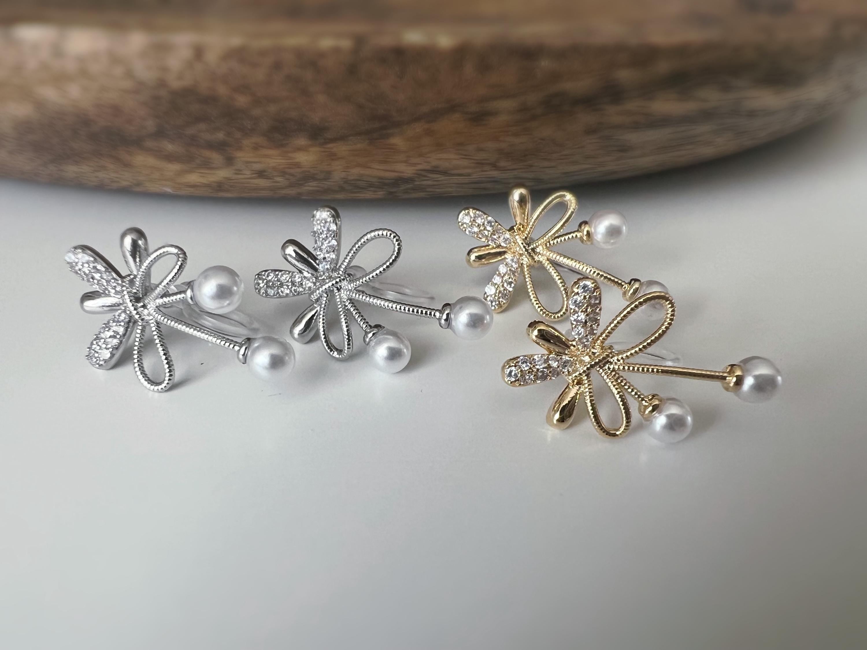 Boucles d’oreilles à clips fleurs strass, mini perles blanches couleur Or / Argent. Design raffiné pour un look délicat, sans perçage.