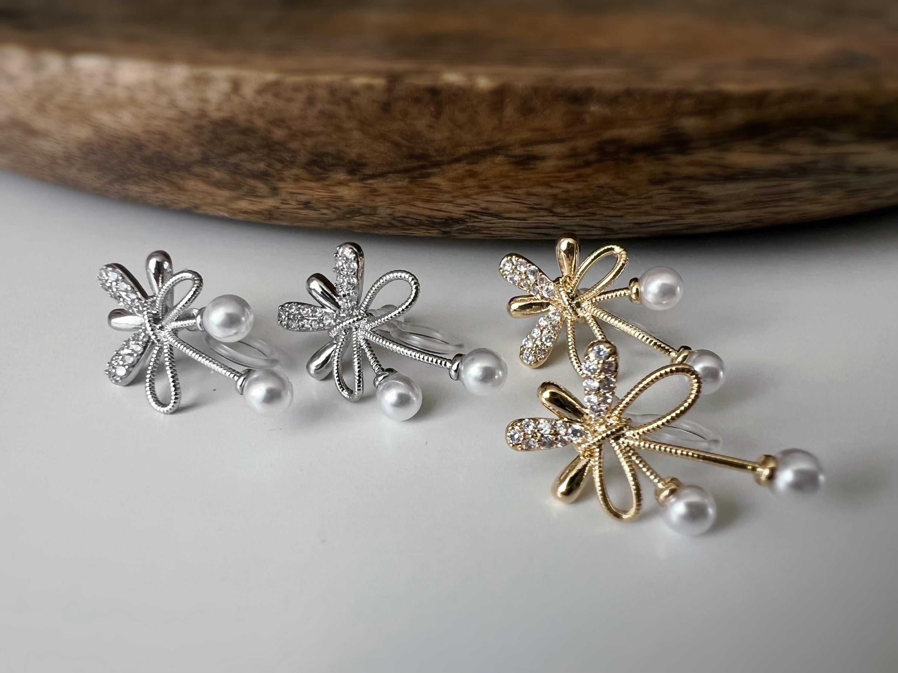 Boucles d’oreilles à clips fleurs strass, mini perles blanches couleur Or / Argent. Design raffiné pour un look délicat, sans perçage.