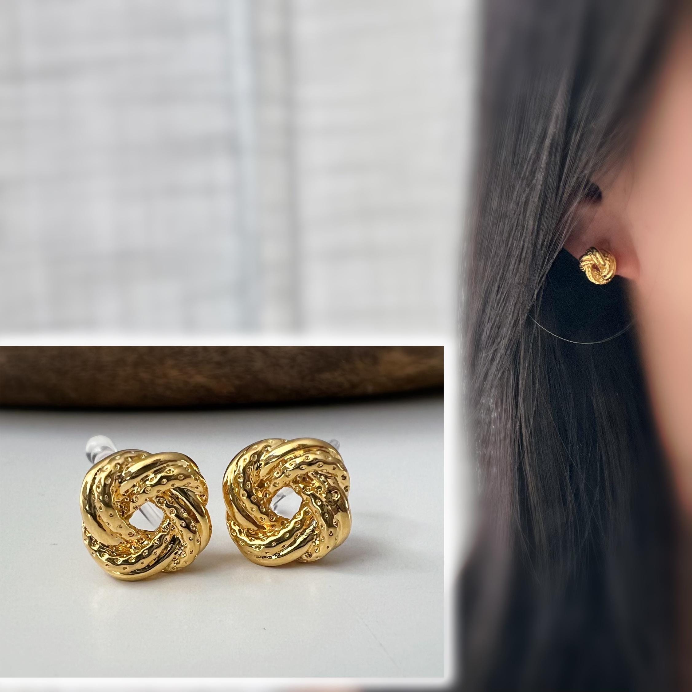 Clips d’oreilles nœud doré au design texturé. Élégantes et intemporelles, elles ajoutent une touche chic à toutes vos tenues.