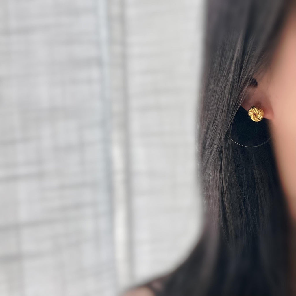 Clips d’oreilles nœud doré au design texturé. Élégantes et intemporelles, elles ajoutent une touche chic à toutes vos tenues.