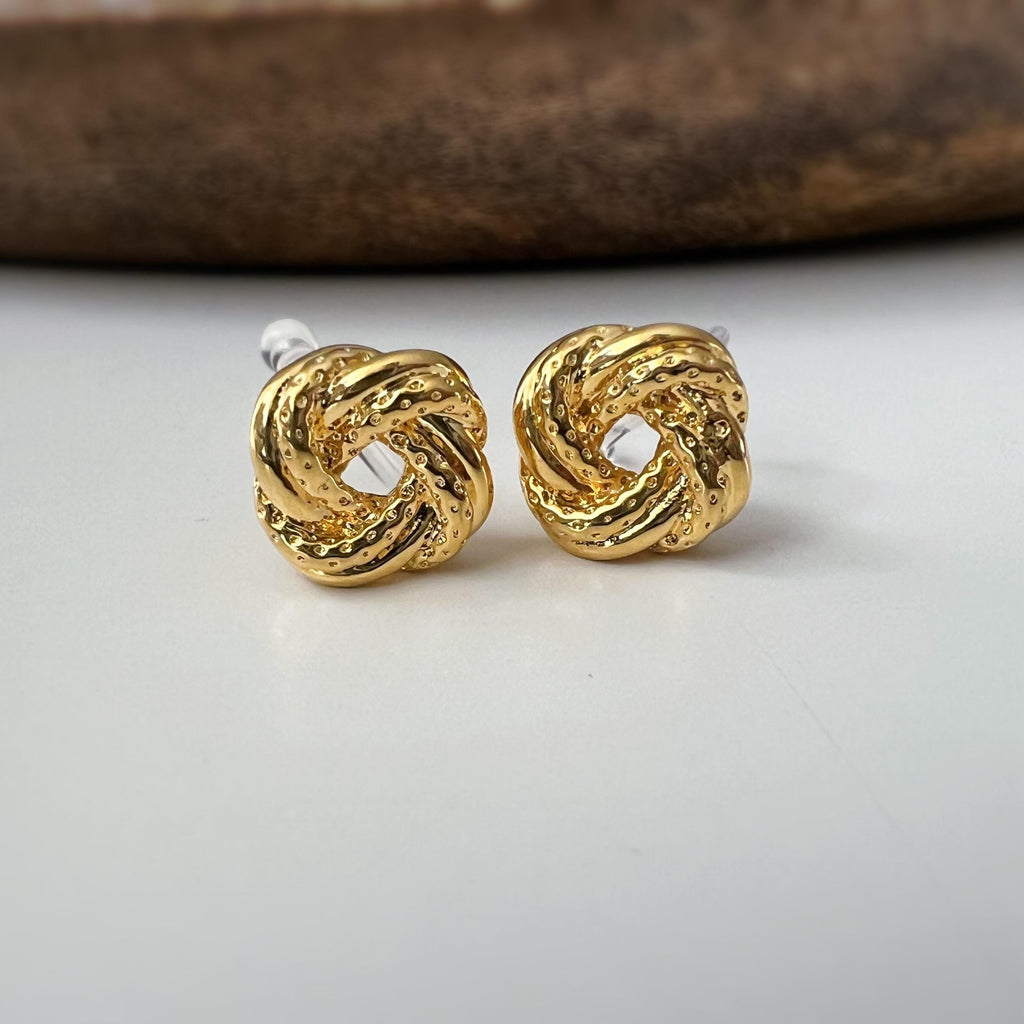 Clips d’oreilles nœud doré au design texturé. Élégantes et intemporelles, elles ajoutent une touche chic à toutes vos tenues.