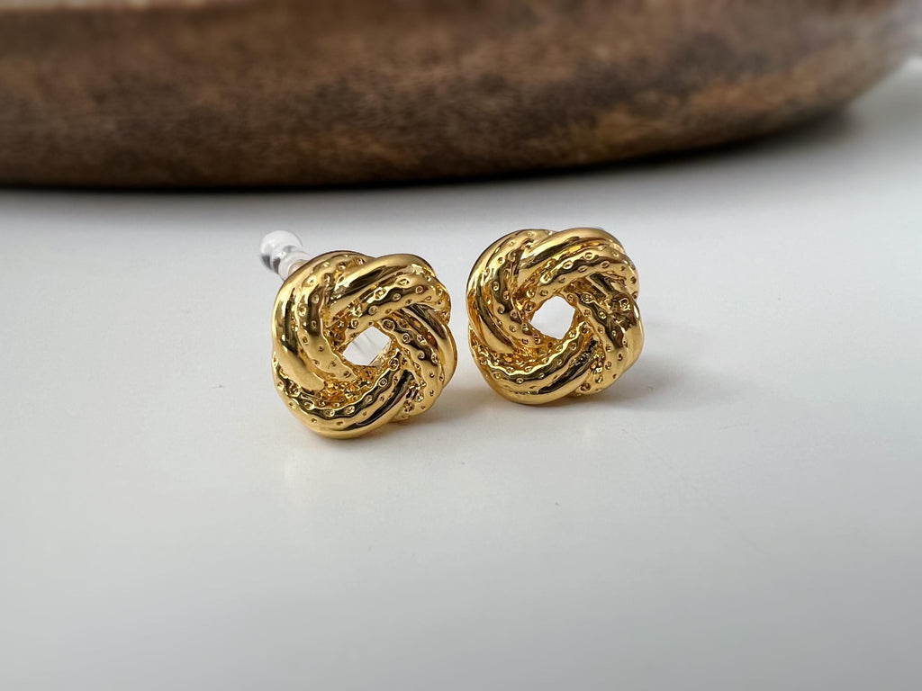 Clips d’oreilles nœud doré au design texturé. Élégantes et intemporelles, elles ajoutent une touche chic à toutes vos tenues.