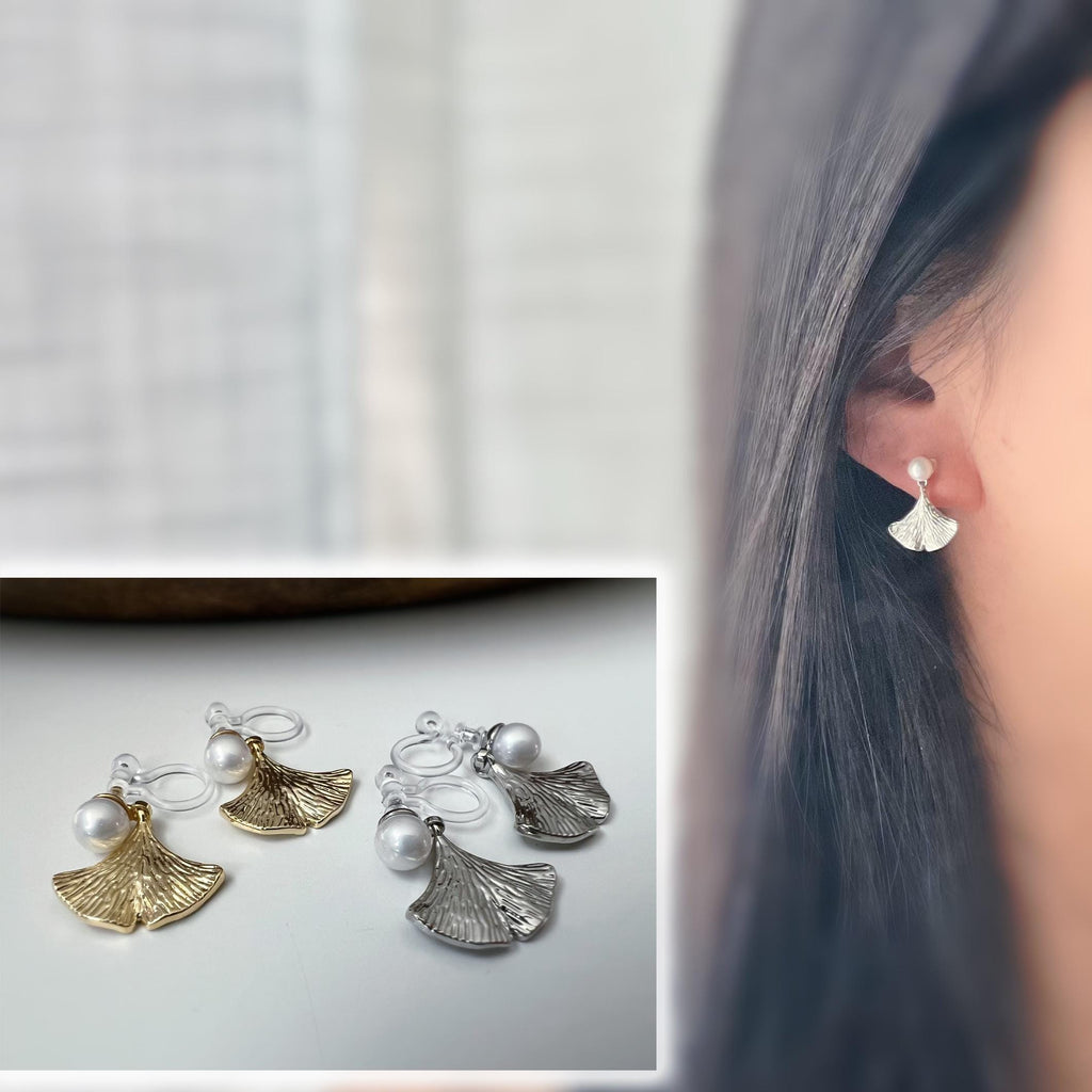 Clips d’oreilles élégants ornés d’une perle blanche et d’un pendentif feuille de ginkgo Or / Argent. Un bijou raffiné, chic et intemporel.