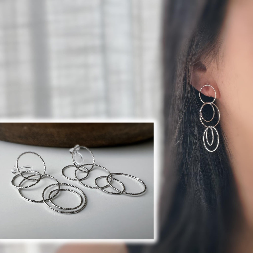 Boucles d'oreilles Clips, anneaux entrelacés argentés. Élégantes et légères, elles subliment vos looks avec une touche moderne et raffinée.