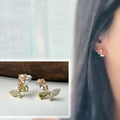 Clips d’oreilles papillon raffinés sertis de cristaux étincelants aux teintes champagne et vert olive. Un bijou délicat et lumineux.