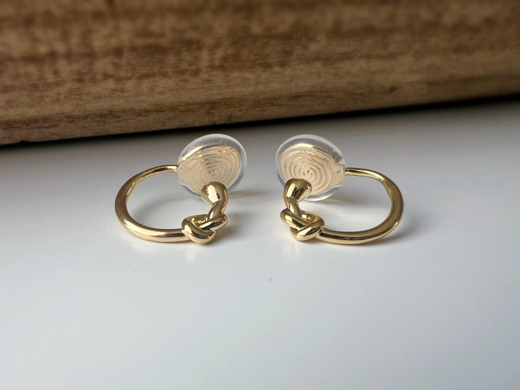 Créoles à clip minimalistes en argent ou doré, design noué élégant et discret, parfaites pour un style raffiné sans perçage d’oreilles.