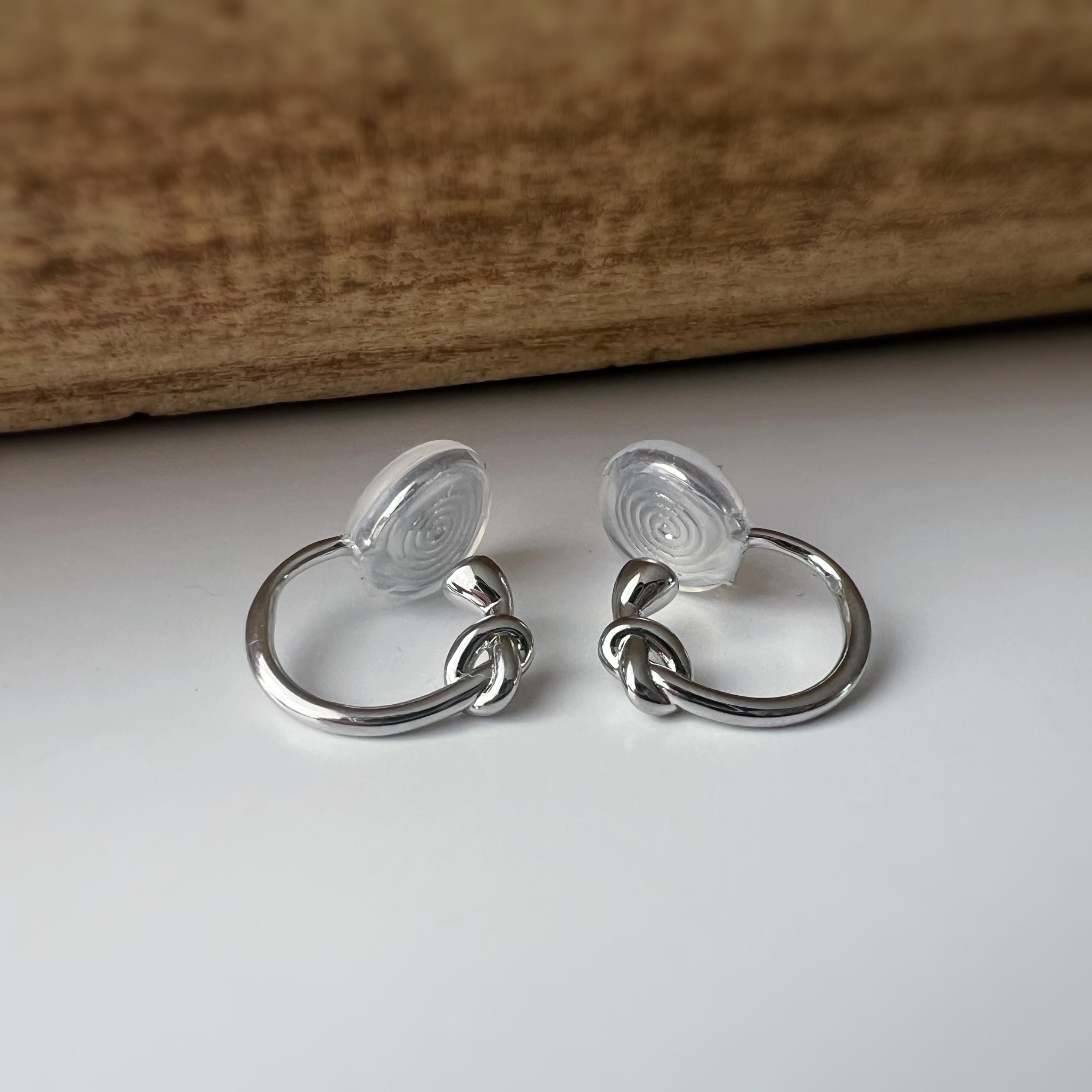 Créoles à clip minimalistes en argent ou doré, design noué élégant et discret, parfaites pour un style raffiné sans perçage d’oreilles.