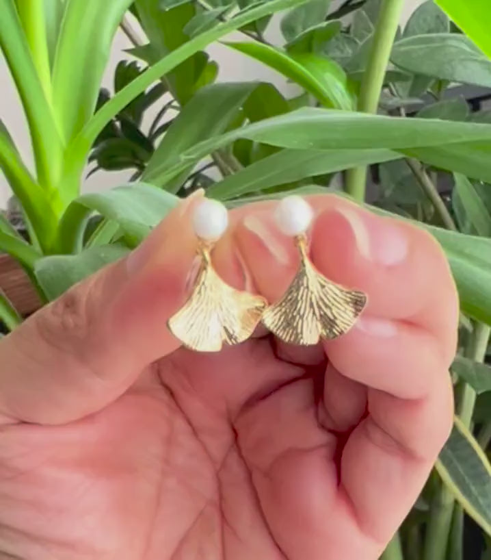 Clips d’oreilles élégants ornés d’une perle blanche et d’un pendentif feuille de ginkgo Or / Argent. Un bijou raffiné, chic et intemporel.