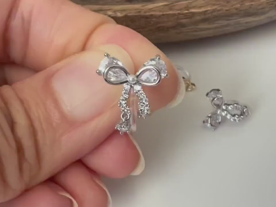 Clips d’oreilles papillon en strass, disponibles en doré et argenté. Design raffiné pour un look délicat, sans perçage.